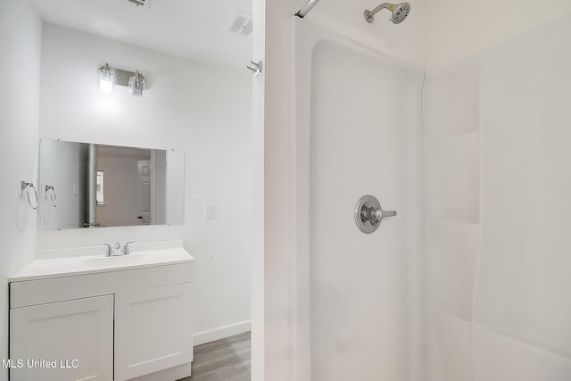 full bathroom with a shower, wood finished floors, and vanity