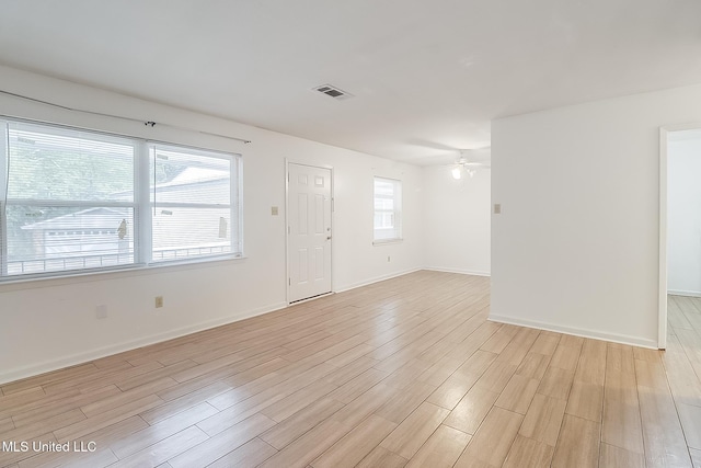 interior space with light wood finished floors, plenty of natural light, visible vents, and a ceiling fan