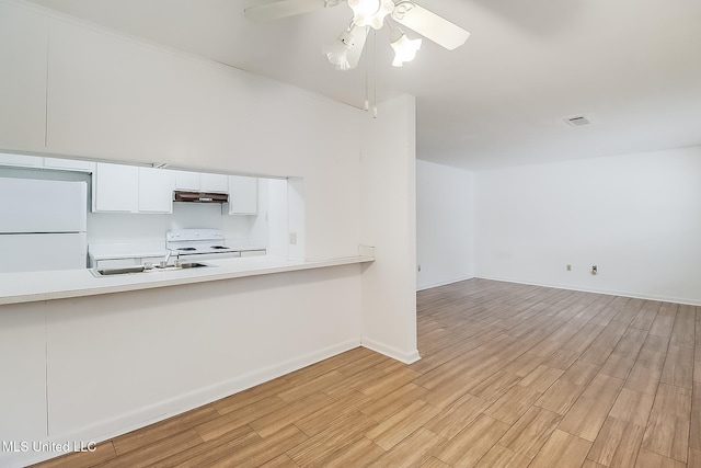 interior space with ceiling fan, a sink, visible vents, baseboards, and light wood-type flooring