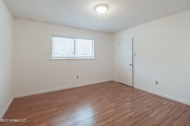 empty room featuring light wood-style flooring and baseboards