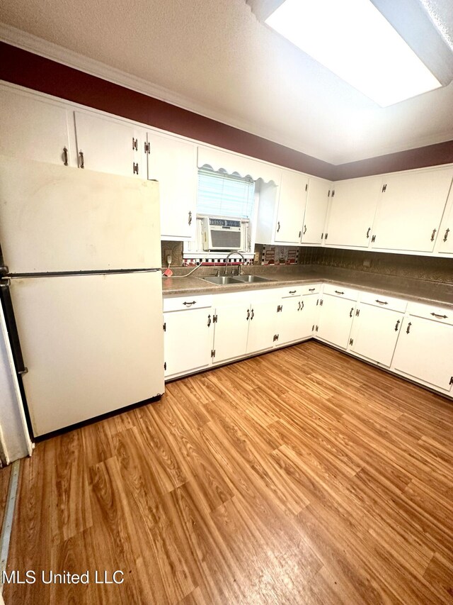 176 Revell Rd, Grenada, MS 38901 - kitchen featuring freestanding refrigerator, light wood finished floors, white cabinets, and a sink