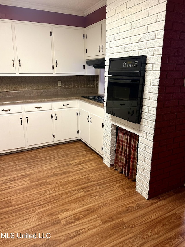 176 Revell Rd, Grenada, MS 38901 - kitchen with black appliances, crown molding, white cabinets, light wood finished floors, and extractor fan