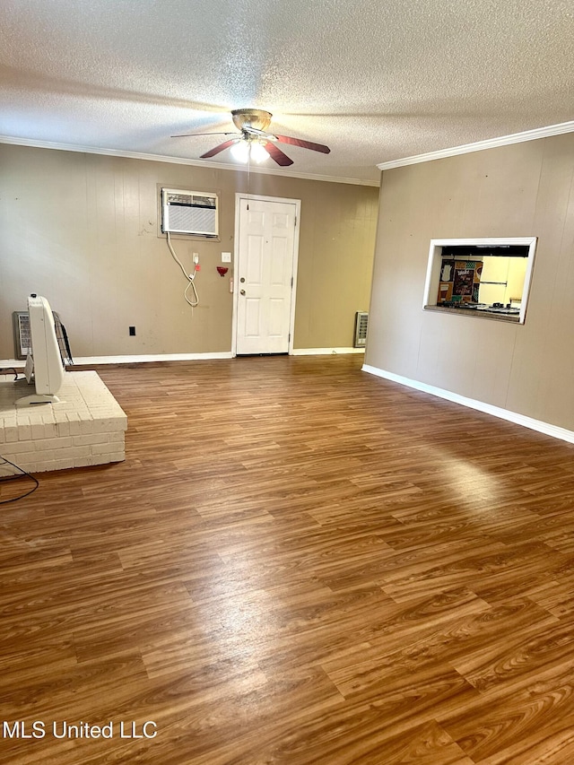 176 Revell Rd, Grenada, MS 38901 - unfurnished living room with a wall mounted air conditioner, a ceiling fan, wood finished floors, a textured ceiling, and ornamental molding