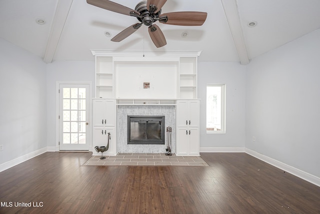 unfurnished living room with lofted ceiling with beams, a fireplace, and baseboards