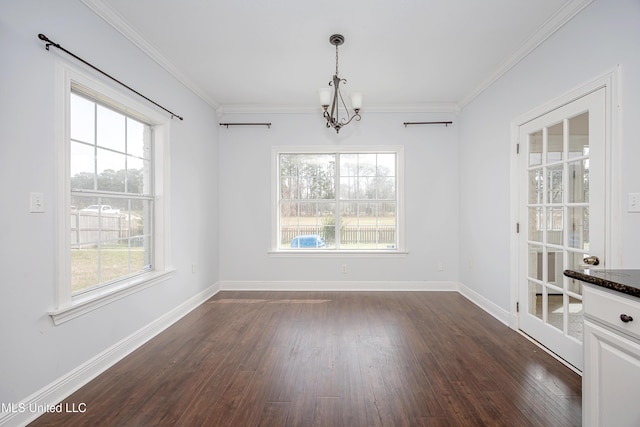 unfurnished dining area with a notable chandelier, dark wood-style flooring, baseboards, and crown molding