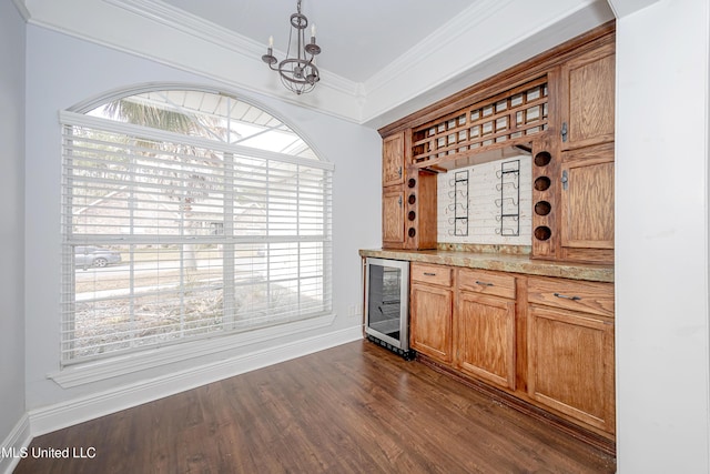 bar with baseboards, wine cooler, ornamental molding, dark wood-type flooring, and decorative light fixtures