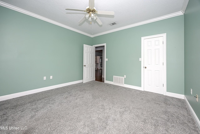 empty room with carpet floors, ornamental molding, visible vents, and a ceiling fan