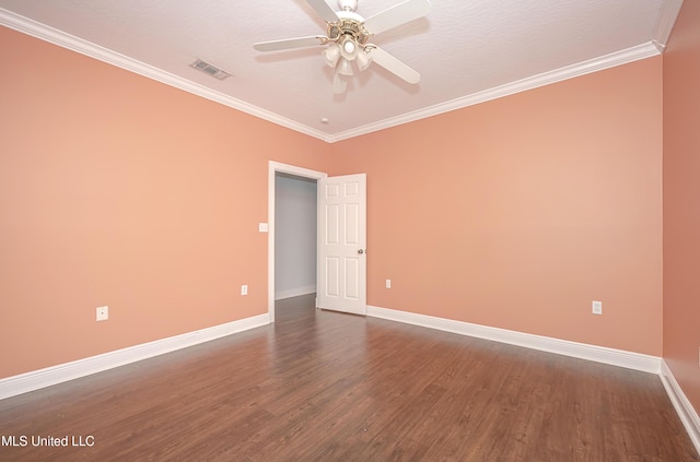 spare room featuring ornamental molding, visible vents, baseboards, and wood finished floors