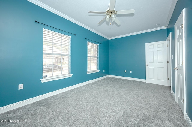 empty room with ornamental molding, carpet, baseboards, and a ceiling fan