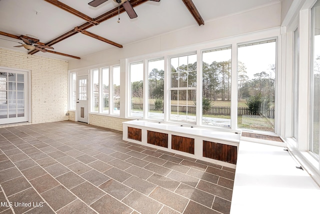 unfurnished sunroom with a ceiling fan and beam ceiling