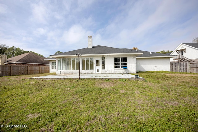 back of house featuring a patio area, a lawn, a fenced backyard, and brick siding