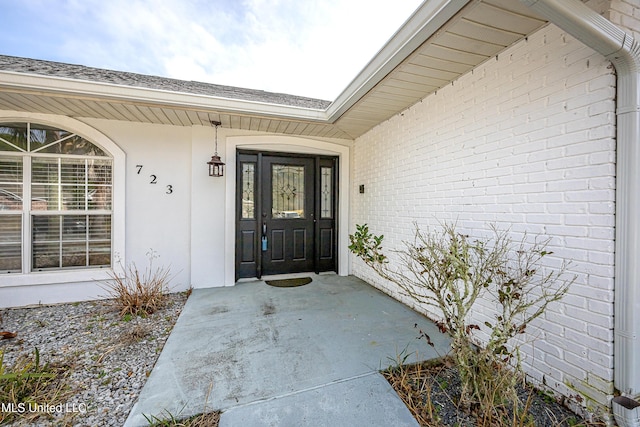 doorway to property featuring brick siding