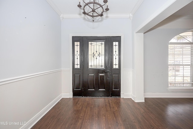 foyer entrance with baseboards, an inviting chandelier, dark wood finished floors, and crown molding