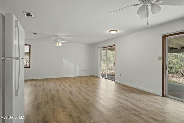 spare room with a ceiling fan, baseboards, visible vents, and wood finished floors