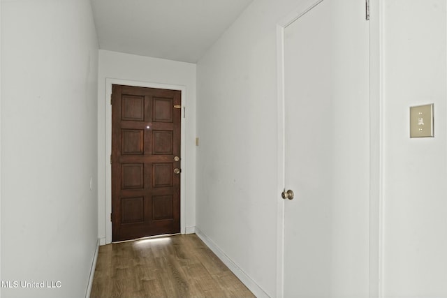 entryway with baseboards and wood finished floors