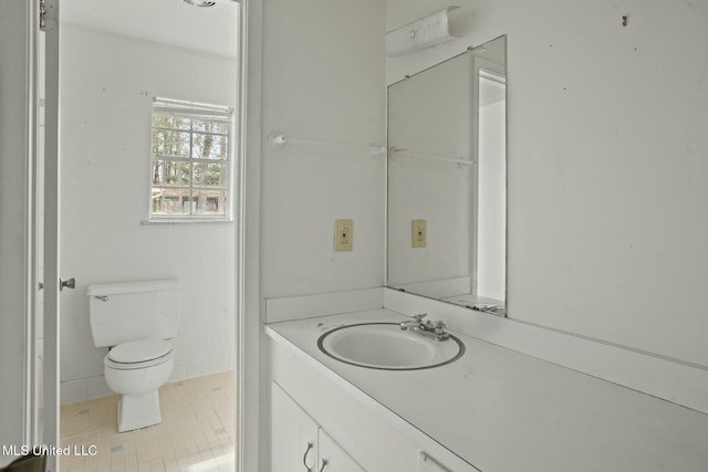 bathroom with toilet, vanity, and tile patterned floors