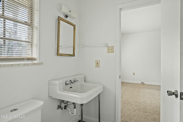 half bath with baseboards and toilet