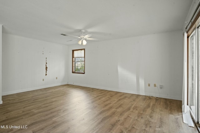 unfurnished room with ceiling fan, wood finished floors, visible vents, and baseboards