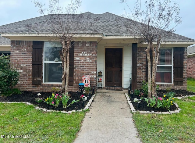 doorway to property with a lawn