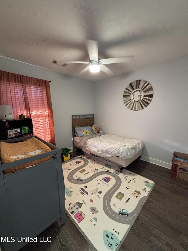 bedroom featuring a textured ceiling, ceiling fan, and dark wood-type flooring