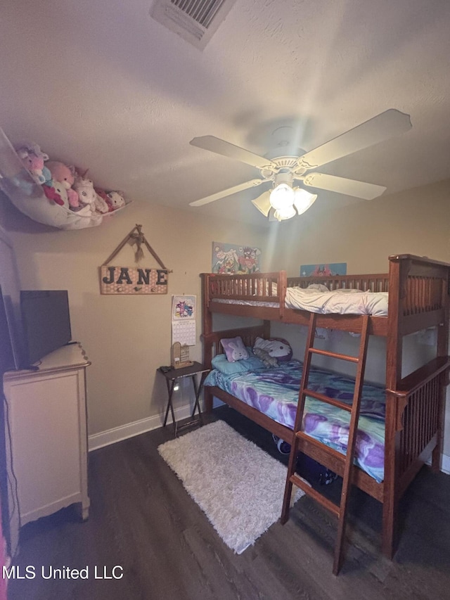 bedroom with dark hardwood / wood-style floors and ceiling fan