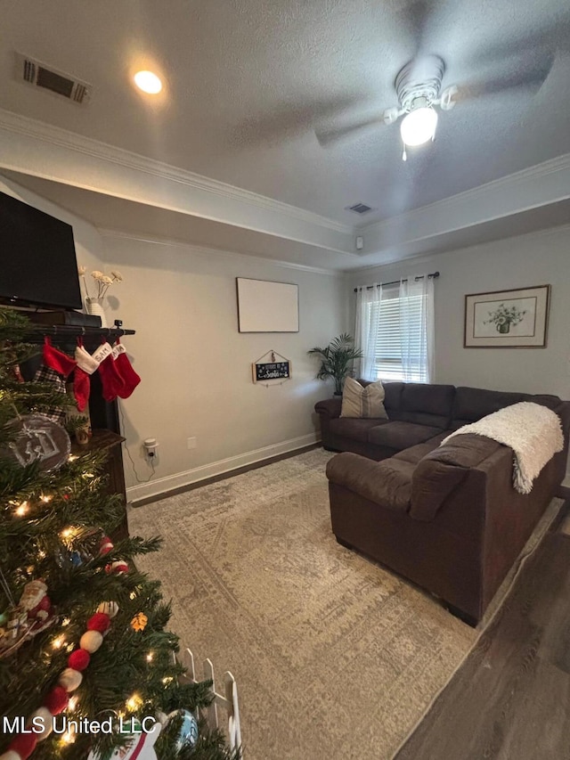 living room featuring ceiling fan, crown molding, hardwood / wood-style floors, and a textured ceiling