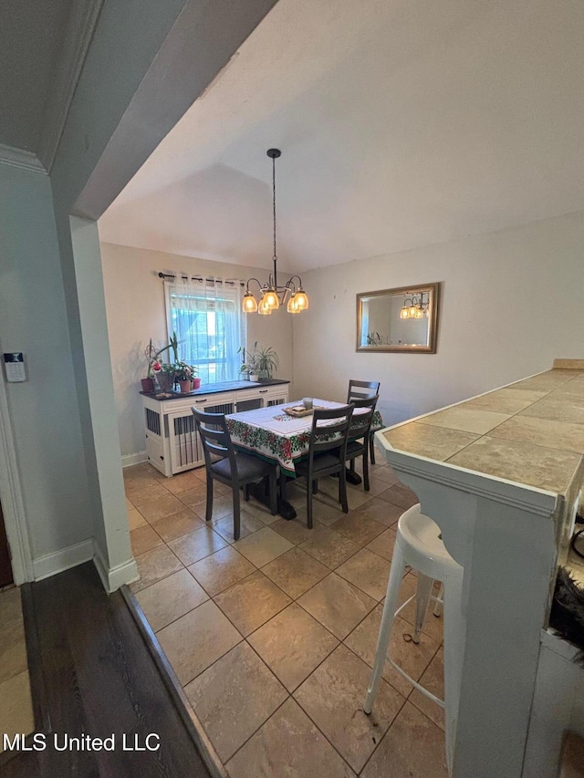 tiled dining room with lofted ceiling and an inviting chandelier