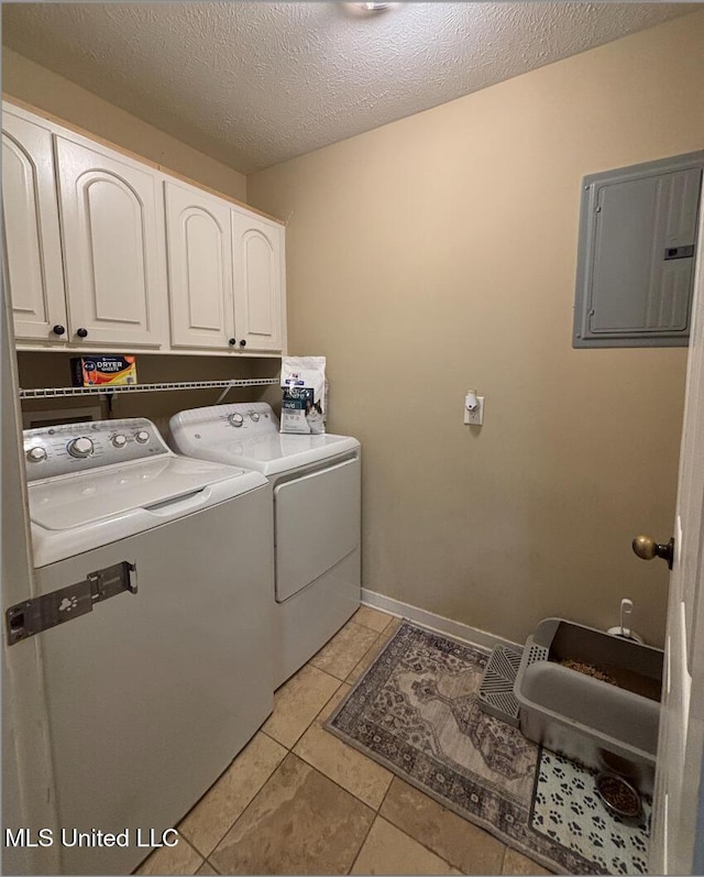 laundry room featuring cabinets, electric panel, washer and dryer, light tile patterned floors, and a textured ceiling