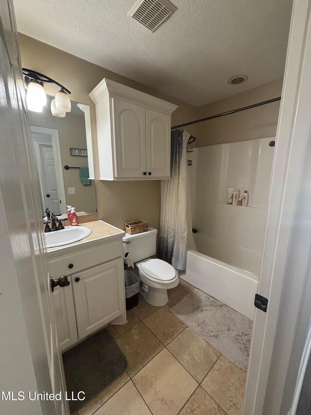 full bathroom with shower / bath combo with shower curtain, vanity, a textured ceiling, and tile patterned flooring