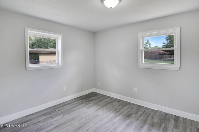 spare room with a wealth of natural light and hardwood / wood-style floors