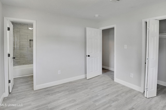 unfurnished bedroom featuring light hardwood / wood-style floors and ensuite bathroom