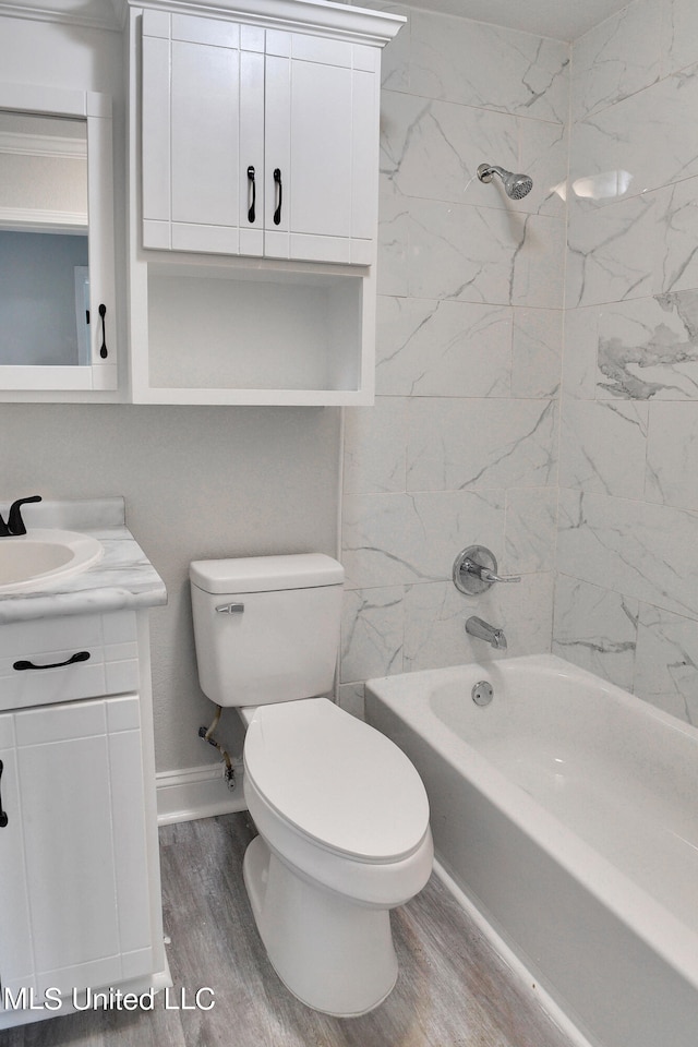 full bathroom with toilet, tiled shower / bath combo, hardwood / wood-style flooring, and vanity