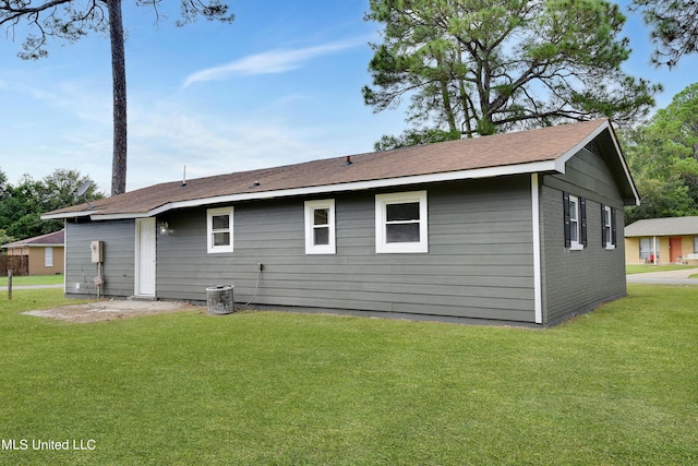 rear view of property with brick siding and a lawn