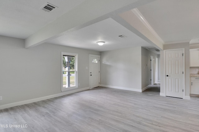 interior space featuring crown molding, beam ceiling, and light wood-type flooring