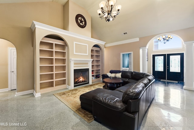 living room featuring french doors, ornate columns, an inviting chandelier, built in features, and high vaulted ceiling