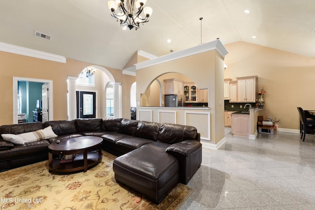 living room with high vaulted ceiling, ornamental molding, ornate columns, a notable chandelier, and sink