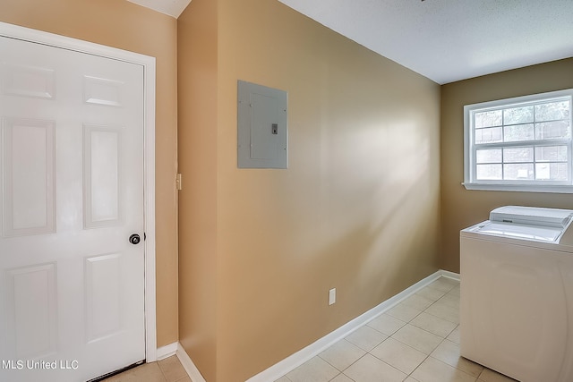 clothes washing area with light tile patterned flooring, washer / clothes dryer, electric panel, and a textured ceiling