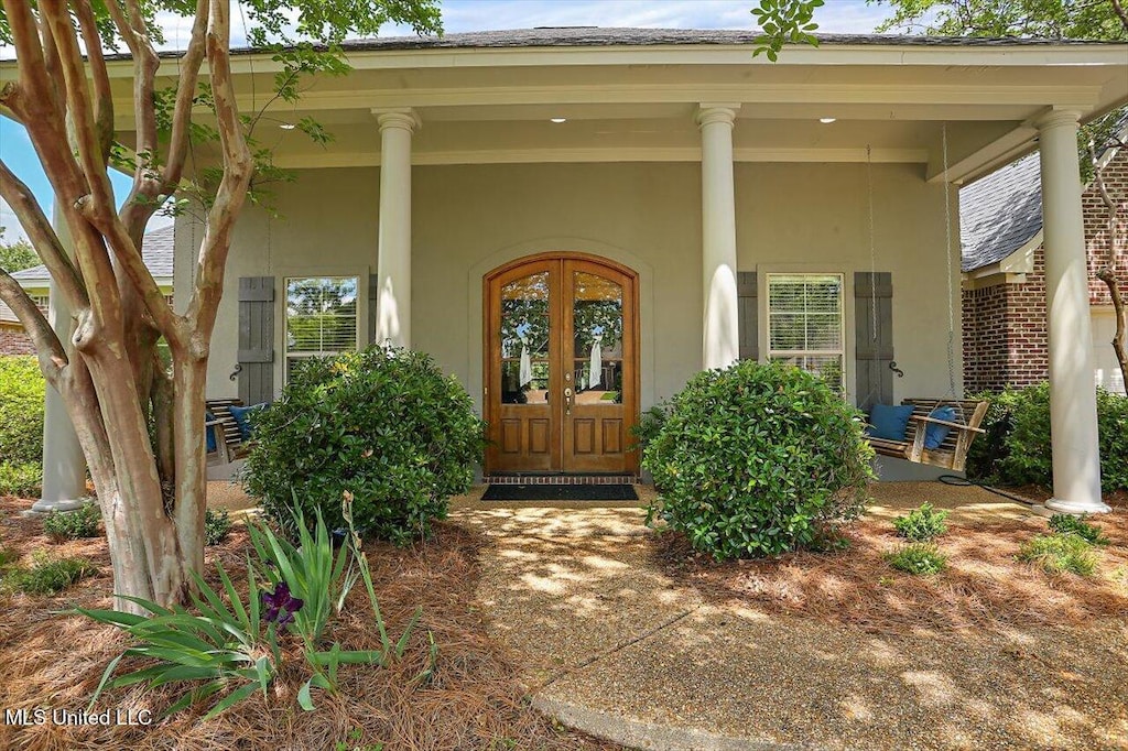 entrance to property with french doors and a porch