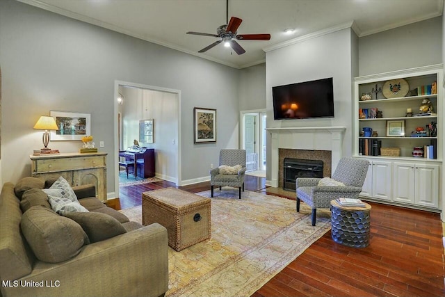 living room with a high ceiling, crown molding, ceiling fan, and dark hardwood / wood-style flooring