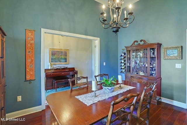 dining area with dark hardwood / wood-style flooring and a notable chandelier