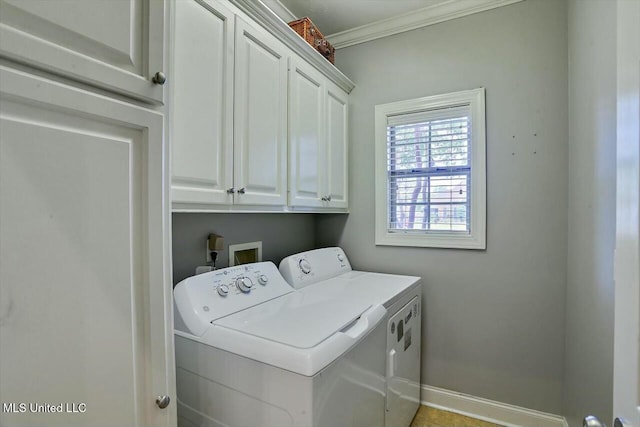 clothes washing area featuring crown molding, cabinets, and washer and dryer