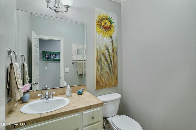 bathroom featuring vanity, a notable chandelier, and toilet