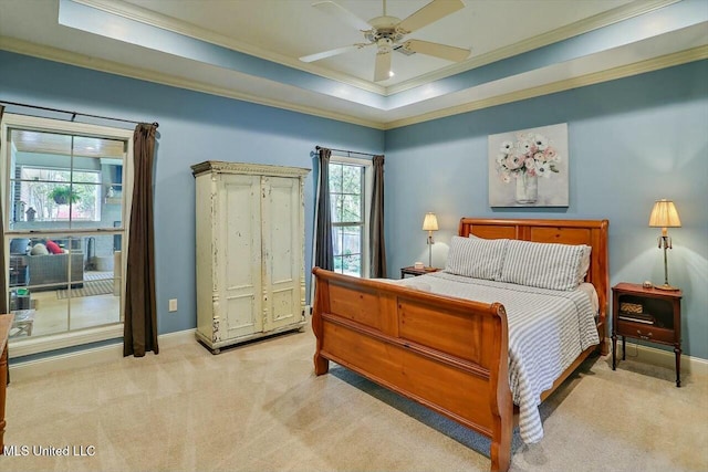 carpeted bedroom featuring ornamental molding, ceiling fan, and a tray ceiling