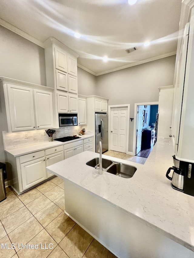 kitchen featuring white cabinetry, appliances with stainless steel finishes, backsplash, and a high ceiling