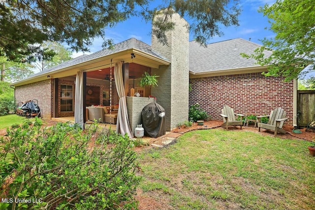 rear view of property featuring a sunroom and a lawn