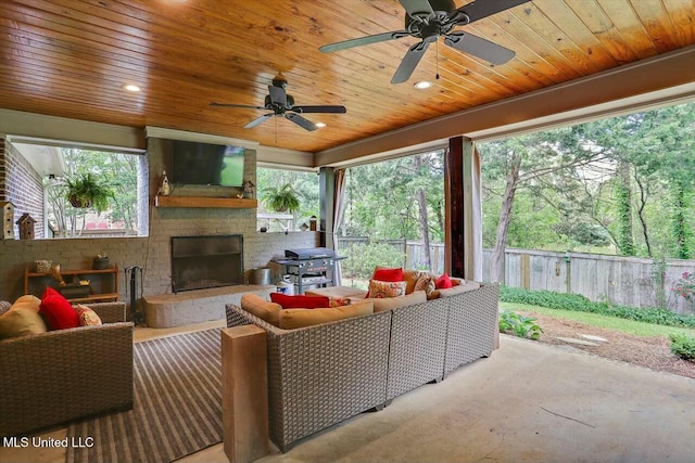 exterior space featuring ceiling fan, a grill, and an outdoor living space with a fireplace