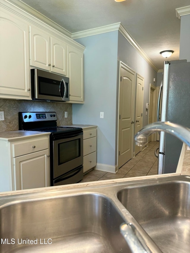 kitchen with crown molding, stainless steel appliances, backsplash, and light tile patterned floors