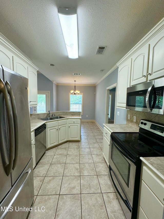 kitchen with light tile patterned floors, a chandelier, pendant lighting, crown molding, and stainless steel appliances