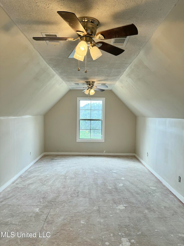 additional living space featuring a textured ceiling, vaulted ceiling, and ceiling fan