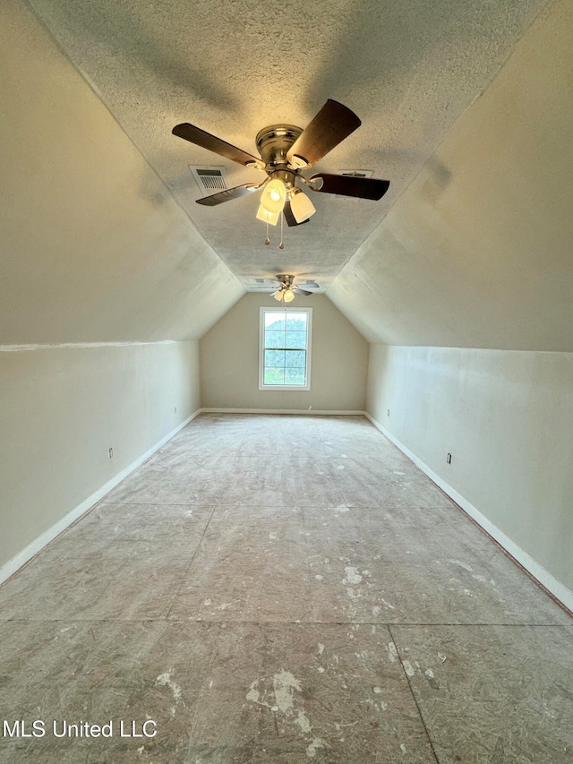 bonus room with a textured ceiling, ceiling fan, and vaulted ceiling